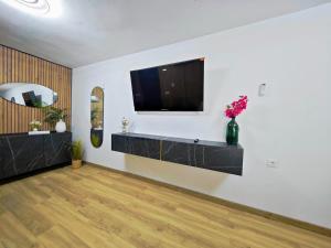 ein Wohnzimmer mit einem Flachbildfernseher an der Wand in der Unterkunft Casa boutique premium con diseño de autor y confort in Hinojosa del Duque + 31 Fotos