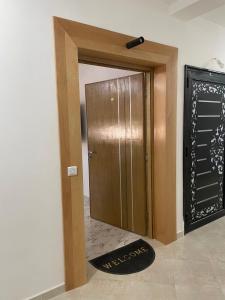 a wooden door with a welcome mat in front of it at Riad Ajdir Al Hoceima in Andalouciene