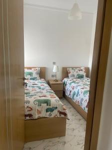 a bedroom with two beds and a open door at Riad Ajdir Al Hoceima in Andalouciene