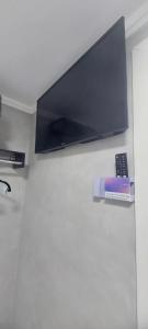 a flat screen tv on a wall with a remote control at Suites Essepê Quartin! Expo Center Norte, Anhembi, Rodoviaria Tiete, Feira da Madrugada, Brás in Sao Paulo