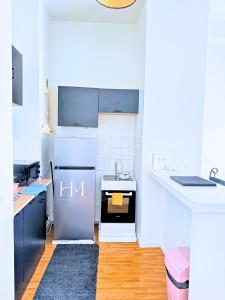 une cuisine blanche avec une cuisinière et un évier dans l'établissement HeavenlyHome-Paris-CDG-Stade-de-France, à Domont