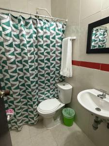 a bathroom with a toilet and a sink and a shower curtain at Hotel Rosandy Galaxy in Cartagena de Indias