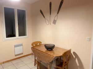 a dining room with a wooden table and utensils on the wall at La Belle Échappée de COURSAC in Coursac