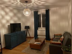 a living room with a couch and a tv at La Belle Échappée de COURSAC in Coursac
