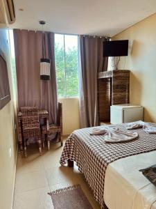 a bedroom with a bed and a chair and a window at Pousada Costa Tropical in Tamandaré +95 photos