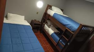 Dos literas en una habitación con sábanas azules. en Lodge Atacama Hostal, en Copiapó