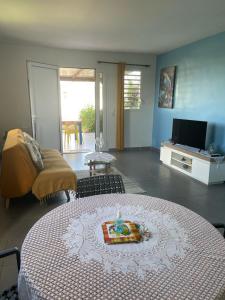 a living room with a table with a candle on it at colibris Location SAINTE-ANNE in Sainte-Anne