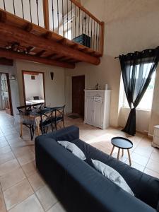 a living room with a blue couch and a table at Le Mas Gabantelye in Saint-Paulet-de-Caisson