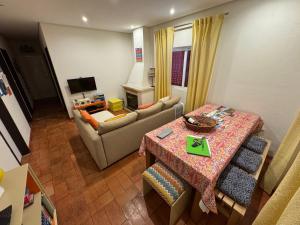 ein Wohnzimmer mit Tisch und Couch in der Unterkunft Quintinha da Evangelina in Açafora