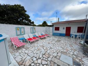 eine Gruppe von Stühlen und Tischen auf einer Steinterrasse in der Unterkunft Quintinha da Evangelina in Açafora