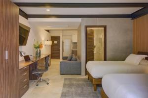 a hotel room with two beds and a desk at MX Grand Suites in Mexico City