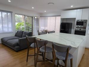 a kitchen and living room with a large marble counter top at Reel Relax Retreat at Dora Creek in Dora Creek