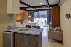 a kitchen with a sink and a room with a bed at MX Grand Suites in Mexico City