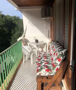 a balcony with a table and chairs on a deck at Espaçoso Flat com Varanda no Cavalinho Branco in Águas de Lindóia