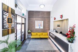 a living room with a yellow couch in a lobby at Quest Invercargill Serviced Apartments in Invercargill