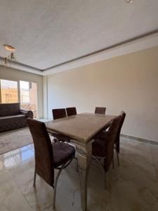 a dining room with a wooden table and chairs at Coronado Dabaa Beach in Zāwiyat ‘Abd al Mun‘im