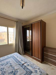 a bedroom with a bed and a cabinet and a window at Coronado Dabaa Beach in Zāwiyat ‘Abd al Mun‘im +11 photos