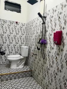 Un baño con inodoro y un teléfono en la pared. en Bajo Komodo Homestay, en Komodo