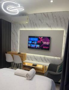 a room with a bed and a tv on a wall at RT properties @ The gardens in Accra