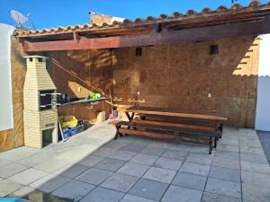 a wooden bench on a patio with a brick wall at Casa com piscina in Juazeiro do Norte +4 photos