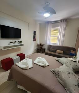 una camera da letto con un letto con due asciugamani sopra di Confortável Flat Cavalinho Branco-Aguas de Lindoia ad Águas de Lindóia Altre 19 foto