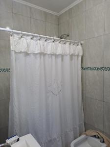 a bathroom with a shower curtain and a toilet at posada acevedo in Acevedo +12 photos