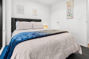 a bedroom with a bed with a blue and white comforter at Flash Stay Deal! Masterpiece Modern 3beds in Hamilton