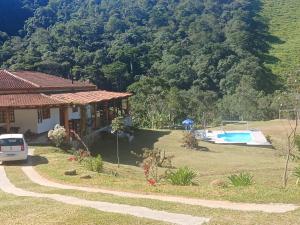 a house with a swimming pool in front of a mountain at Refúgio dos Moreiras in Monteiro Lobato
