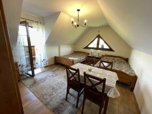 een kamer met een tafel, 2 bedden en een raam bij Pod Białą Skała in Niedzica Zamek +67 foto's