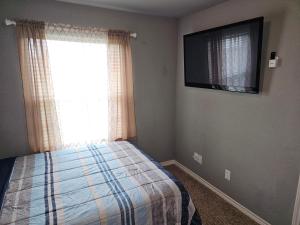 a bedroom with a bed and a flat screen tv at Modern Home near Downtown Dallas in Lancaster