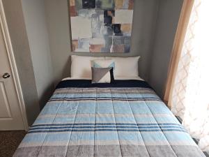 a bed in a small room with a plaid at Modern Home near Downtown Dallas in Lancaster