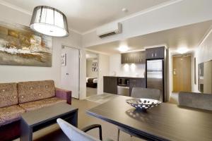 沃加沃加Pavilion Hotel Wagga Wagga的配有桌子和沙发的厨房和客厅