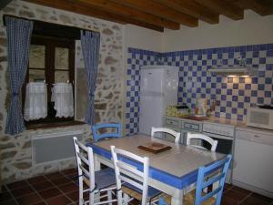 a kitchen with a table and chairs in a kitchen at Gîte Familial avec Cascade, Pêche, Activités et Proximité de Vichy - FR-1-489-21 in Barrais-Bussolles