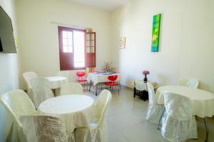a room with white tables and chairs and a window at Hotel Estancia Real in Piura