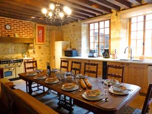 a kitchen with a wooden table with food on it at Élégant cottage médiéval restauré avec piscine, cheminée, proche du golf et attractions culturelles - FR-1-489-335 in Hérisson