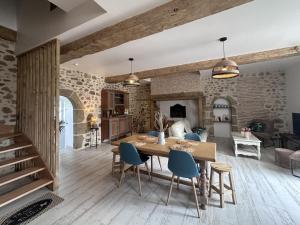 a kitchen and living room with a wooden table and chairs at Gîte Beaucotray rénové 1840 avec jeux pour enfants, campagne paisible - FR-1-489-546 in Rocles