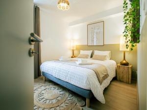 una camera da letto con un letto grande con lenzuola bianche di Gîte de charme avec spa, terrasse et grand jardin, au cœur des vignobles entre Moulins et Vichy - FR-1-489-507 a Saulcet