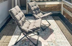 a pair of chairs sitting on a patio at 1 Bedroom Awesome Home In Katwijk Aan Zee in Katwijk aan Zee