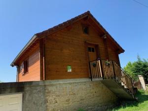 una casa in legno con cancello e garage di Chalet avec Clim, Wi-Fi et Animaux Acceptés à Saint-Bonnet-Tronçais - FR-1-489-445 a Saint-Bonnet-Tronçais