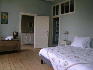 a bedroom with a bed and a door and a table at Maison rénovée 19è, piscine chauffée, sauna, spa, grand parc, proche de la nature spacieuse et tout confort. - FR-1-489-399 in Cérilly +14 photos