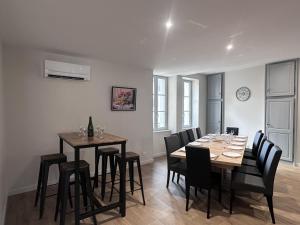a dining room with a table and black chairs at Gîte historique rénové avec jardin et WiFi - FR-1-489-571 in Theneuille
