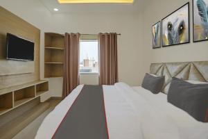 une chambre avec un grand lit et une télévision dans l'établissement Hotel O S.N Sky Awadh, à Lucknow
