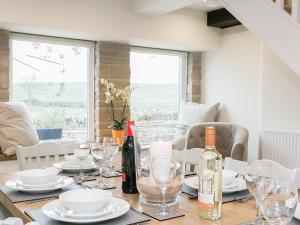 a dining room table with glasses and wine bottles at Manor Cottage in Tideswell