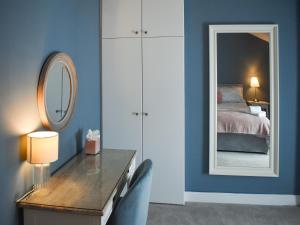 a bedroom with a mirror and a dresser and a bed at No 12 Cottage in Mold