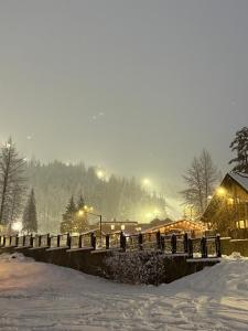 a snow covered bridge with a building in the background at Alyeska Mountain Side Retreat! in Girdwood +3 photos