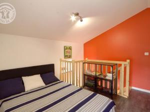 a bedroom with a bed and a red wall at Gîte chaleureux en pierres, terrasse et animaux acceptés à La Chapelle-en-Lafaye - FR-1-496-59 in La Chapelle-en-Lafaye
