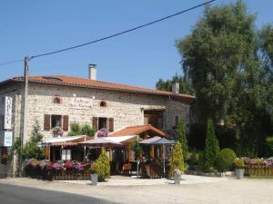 a building with tables and umbrellas in front of it at Gîte rénové en pierres au cœur du Haut Forez avec terrasse et randonnées à proximité - FR-1-496-59 in La Chapelle-en-Lafaye +6 photos