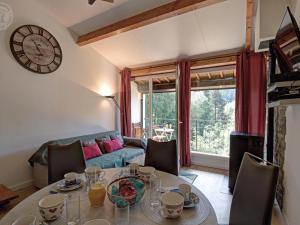 Una sala de estar con una mesa y un reloj en la pared. en Triplex Montagnard avec Sauna et Balcon, Vue Pistes - FR-1-496-338, en Chalmazel Jeansagniere