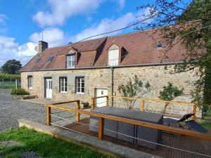 a large deck in front of a stone house at Charmante maison près de Domfront avec 3 ch, animaux admis - FR-1-497-201 in Saint-Gilles-des-Marais