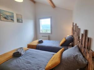 una camera da letto con due letti e una finestra di Gîte 4 pers, terrasse & jardin, près des Bois Noirs - FR-1-496-348 a Saint-Priest-la-Prugne